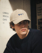 Chico con gorra Core beis frente a una librería