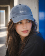 Chica con gorra Core azul junto a un panel azul
