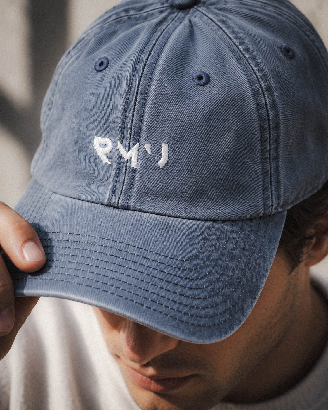Detalle del bordado y la visera de la gorra Core azul puesta