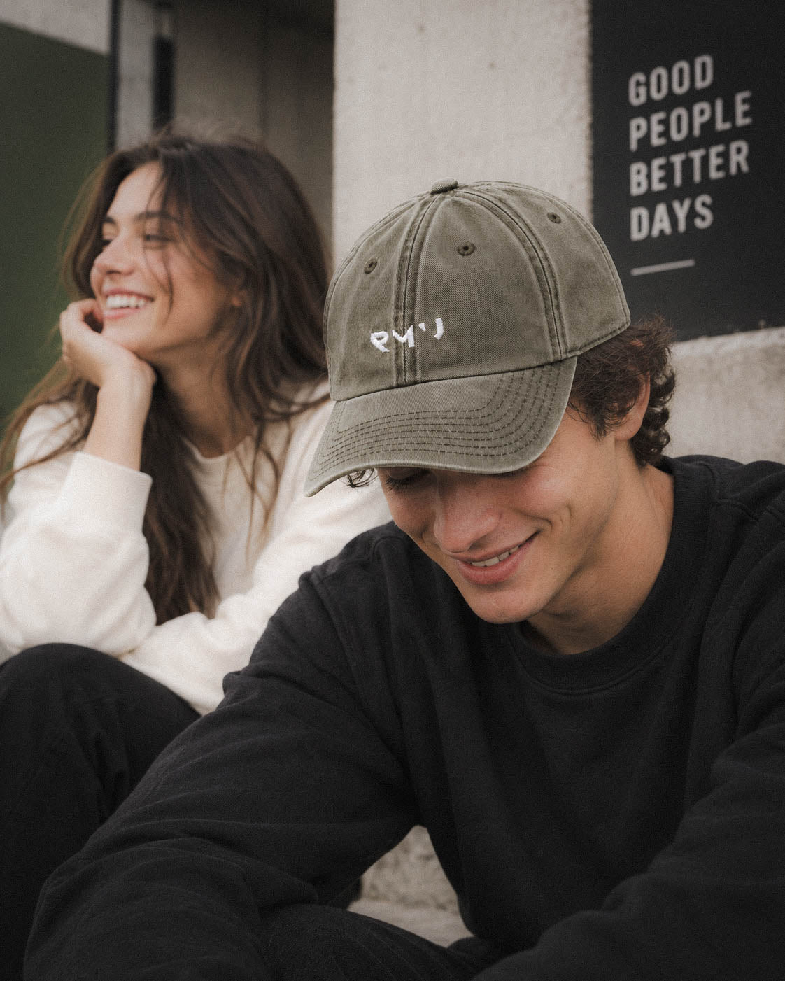 Chico con gorra Core verde oliva en un café con una amiga