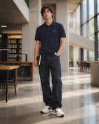 Chico con polo Core azul marino en una biblioteca