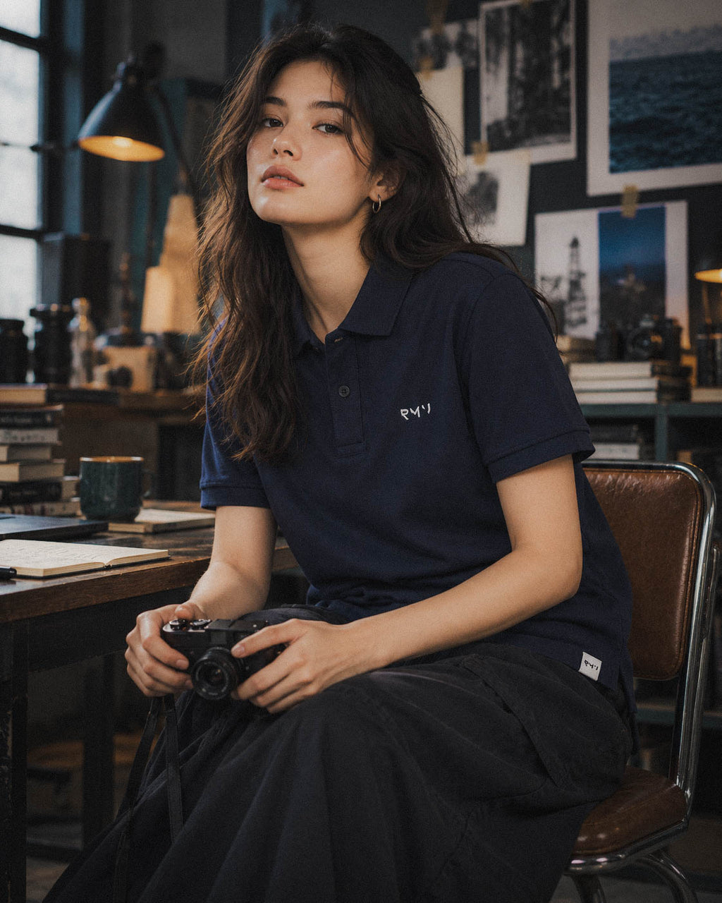 Chica con polo Core azul marino y cámara en un estudio
