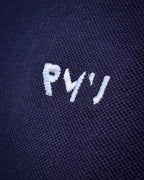 Detalle del bordado blanco RMU y del tejido piqué del polo Core azul marino