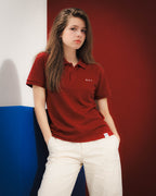 Laura con polo Core burdeos, bordado RMU blanco y pantalón blanco junto a paneles de colores
