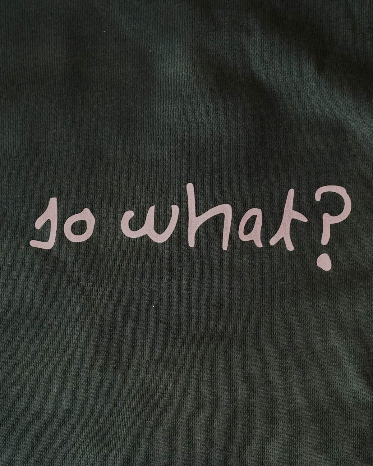 Fotografía real de la camiseta So What verde y su estampado blanco