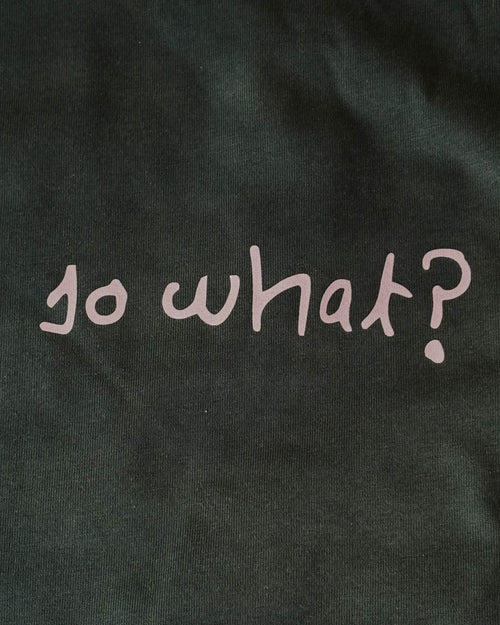 Fotografía real de la camiseta So What verde y su estampado blanco