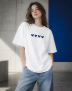 Chica con camiseta Four Hearts junto a un panel azul