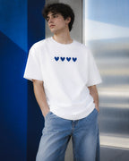 Chico con camiseta Four Hearts blanca en una composición de paneles azules