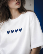 Detalle de los cuatro corazones navy en la camiseta Four Hearts