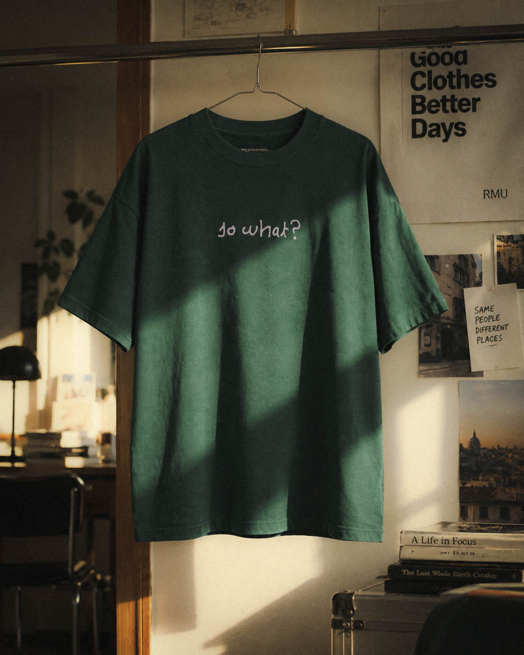 Camiseta So What suspendida en una composición interior con luz de ventana