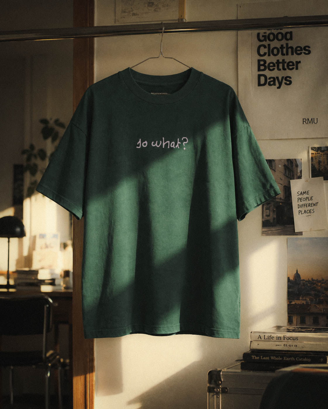Camiseta So What suspendida en una composición interior con luz de ventana