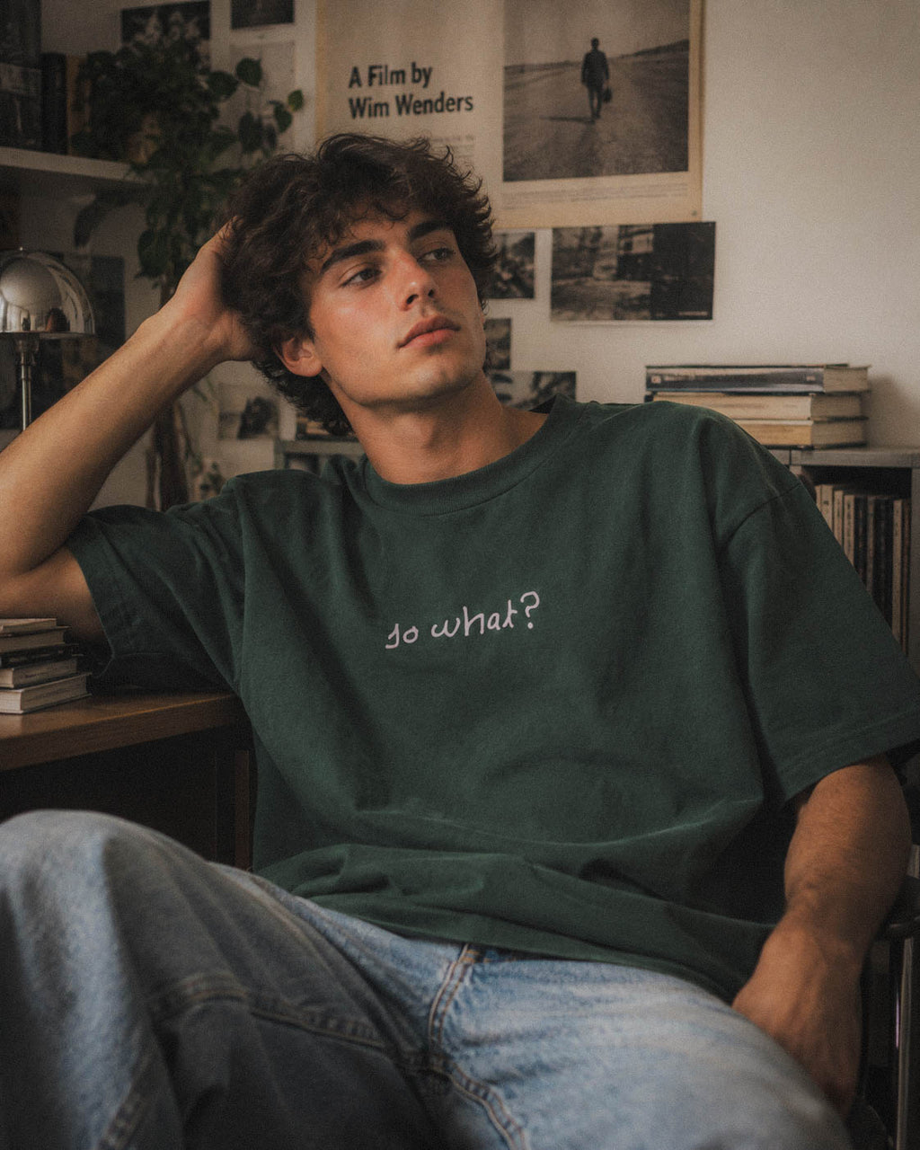 Chico con camiseta So What verde sentado en un estudio